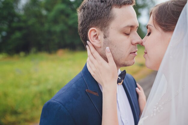 Élégante mariée et le marié posant ensemble à l'extérieur