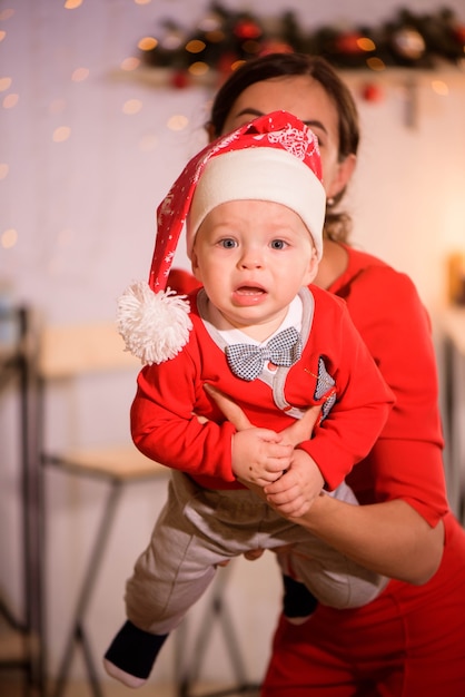 Élégante mère jouant avec bébé garçon dans la chambre