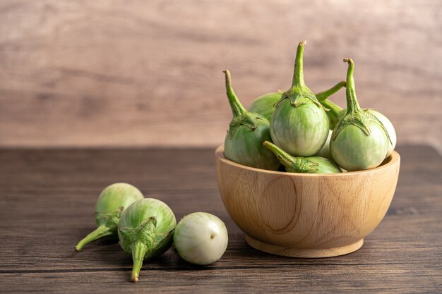 Légume frais d'aubergine verte dans un bol en bois avec espace de copie.