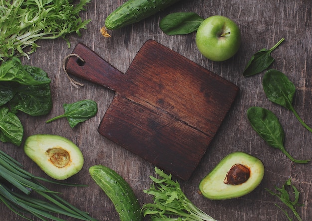 Légume vert sain: épinards, concombre, laitue, pomme et avocat sur fond sombre. Lay plat, espace de copie.