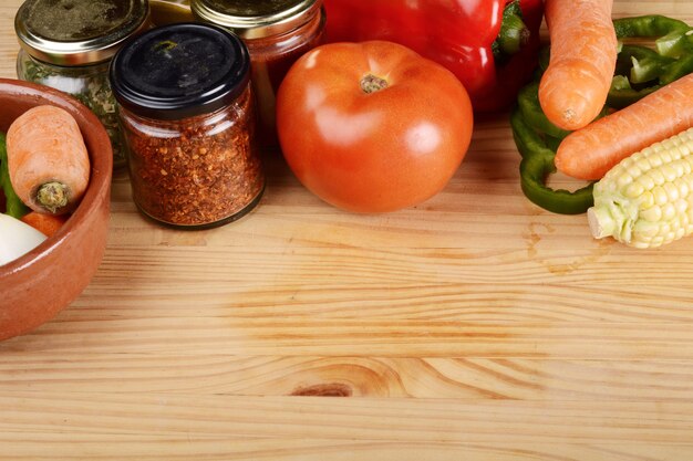 Légumes et assaisonnements sur table en bois.