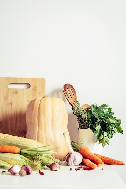 Légumes d'automne et ustensiles de cuisine sur fond de mur de table Concept de nourriture saisonnière