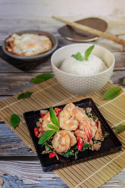 Légumes aux herbes frits aux crevettes servis avec du riz vapeur et des œufs au plat