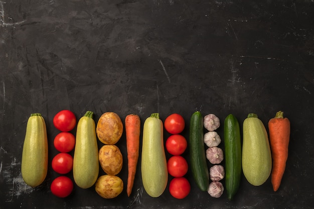 Légumes biologiques frais sur fond noir dans un design plat