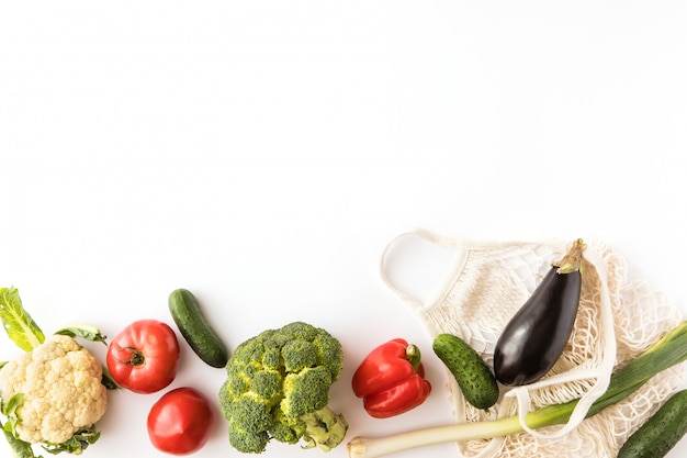 Légumes biologiques frais et sac écologique en coton maillé sur fond blanc