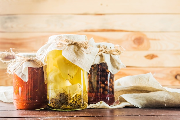 Légumes en conserve sur fond de bois