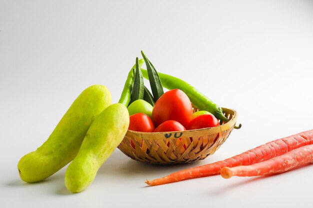 Légumes crus dans un bol en bois sur fond blanc