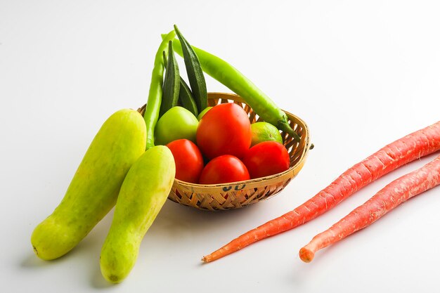 Légumes crus dans un bol en bois sur fond blanc