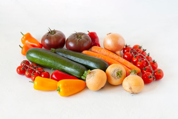 Légumes crus lumineux sur fond blanc