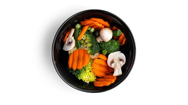 Légumes dans une assiette noire sur fond blanc. Photo de haute qualité