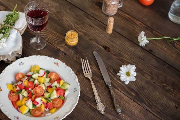 Légumes frais et colorés sur une plaque blanche sur un fond en bois foncé