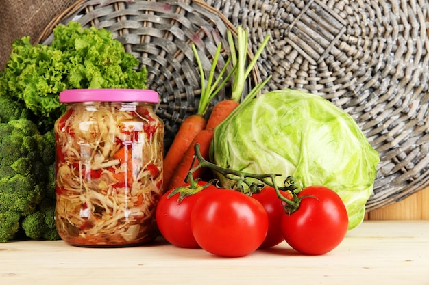 Légumes frais et en conserve sur une table en bois se bouchent