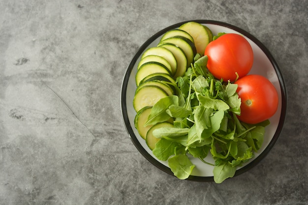 Légumes frais dans une assiette - mélange de salade, tomates et zuchinni. Concept d'aliments sains, perdre du poids.