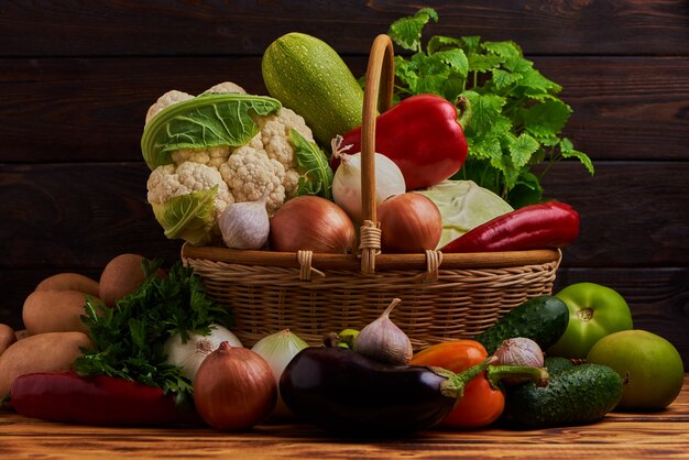 Légumes frais dans le panier sur fond de bois