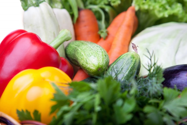 Légumes frais dans un panier de fruits sur blanc