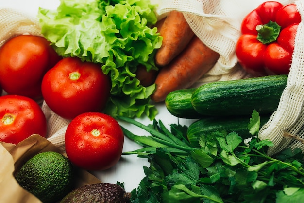 Légumes frais dans des sacs écologiques sur tableau blanc