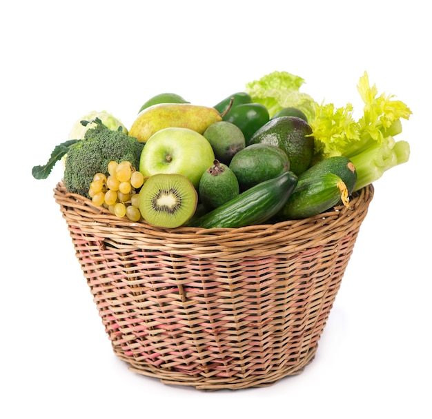 Légumes frais avec des feuilles - kiwi, raisins, pommes et écrasements, concombres, courgettes, brocoli, chou et légumes verts dans le panier isolé sur une surface blanche