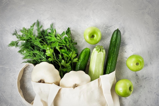 Légumes frais fruits verdure dans un sac en coton réutilisable sur un tabletopfood gris béton