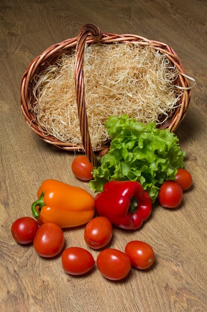 Photo légumes frais et panier en bois sur la table