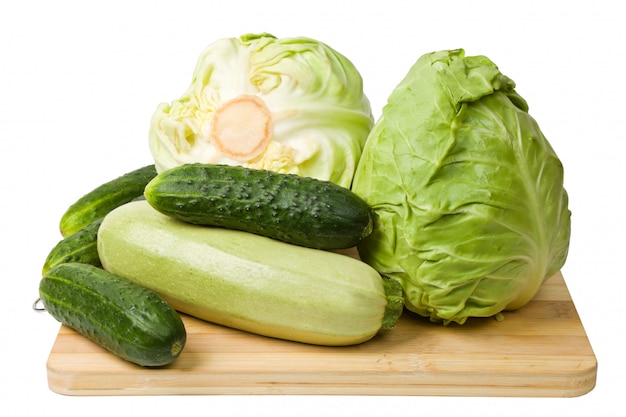 Légumes frais sur une planche à découper en bois isolé sur blanc