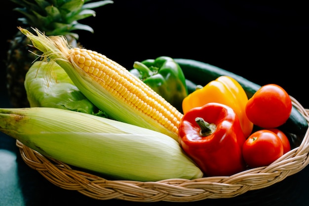 Légumes frais, poivrons, tomates, maïs, concombres et laitue, placés dans un panier