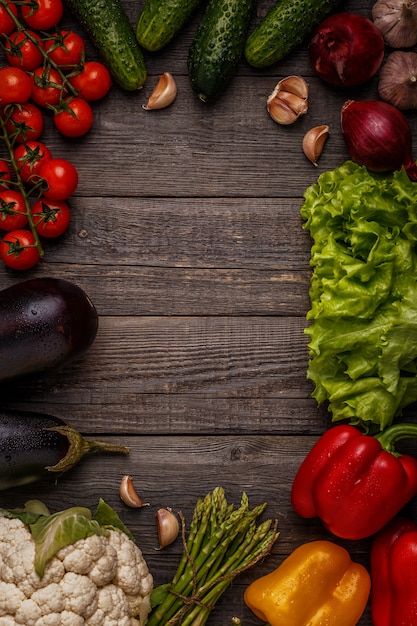 Photo légumes frais pour la cuisson sur fond de bois foncé.