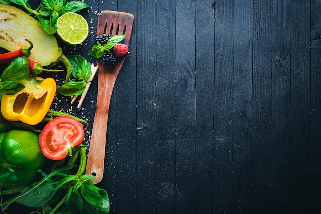 Légumes frais. Préparation pour la cuisson. Sur un fond en bois noir. Vue de dessus. Espace libre pour le texte.