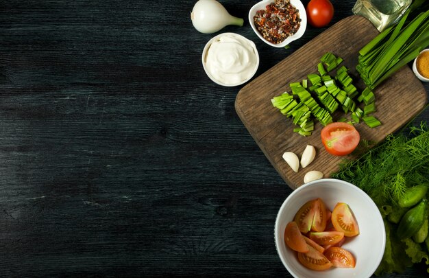 Légumes frais sur un tableau noir sur une surface texturée.