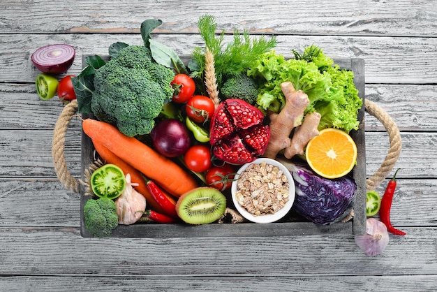 Légumes et fruits frais dans une boîte en bois sur un fond en bois blanc Aliments biologiques Vue de dessus Espace de copie gratuit