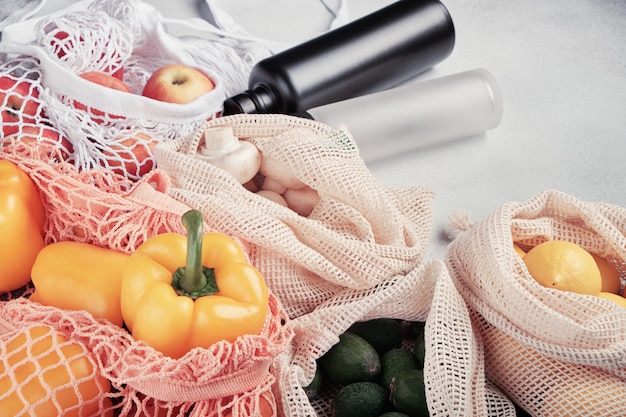 Photo légumes et fruits frais dans des sacs écologiques, bouteilles d'eau réutilisables