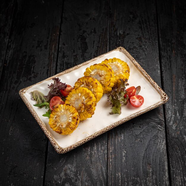 Légumes grillés appétissants sur des assiettes sur une table en bois sombre