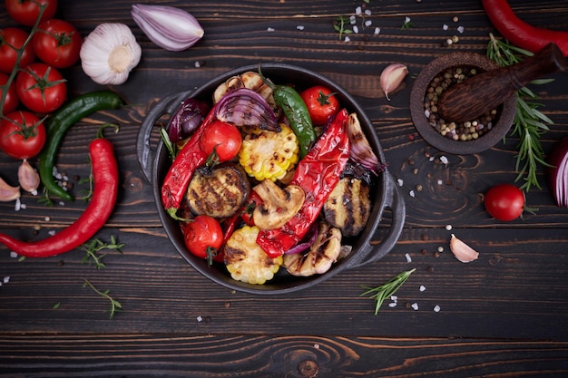 Légumes grillés dans une assiette en céramique noire sur table à la cuisine domestique