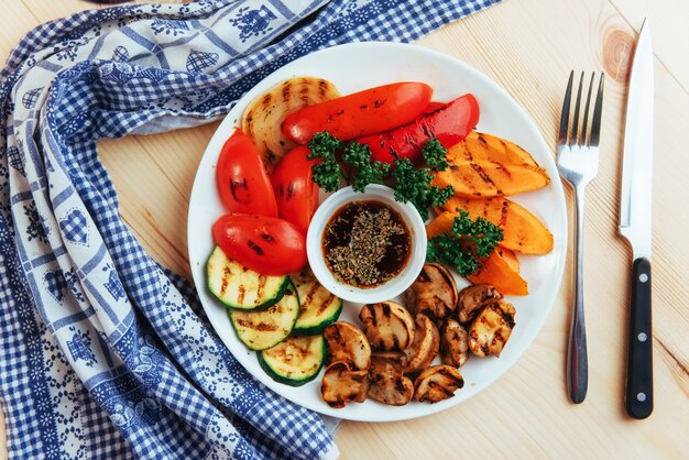 Photo légumes grillés avec sauce sur une table en bois