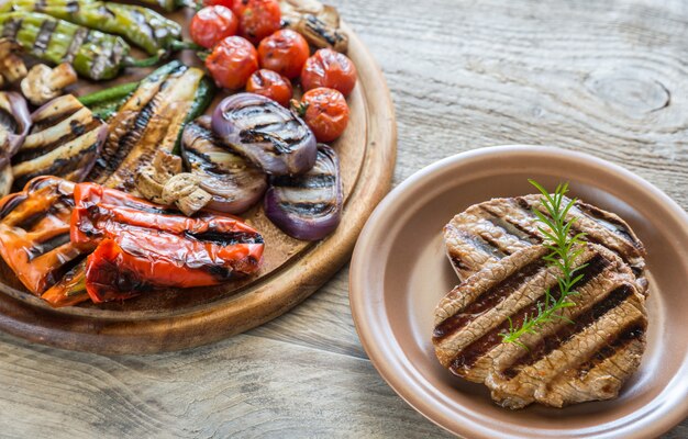 Légumes grillés avec steak de boeuf sur la planche de bois