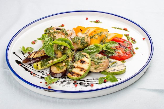 Légumes grillés tomates courgettes aubergines poivrons champignons Dans une assiette blanche