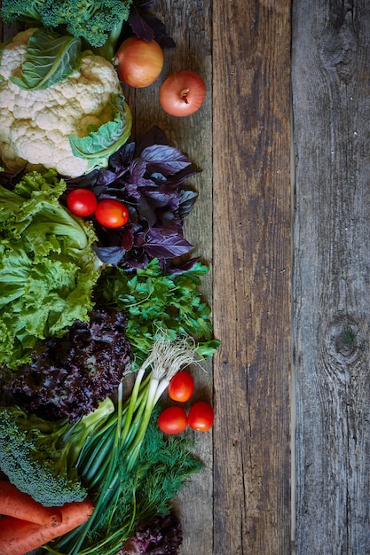 Légumes et herbes fraîches sur une vieille surface en bois brute