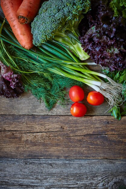 Légumes et herbes fraîches sur une vieille surface en bois brute