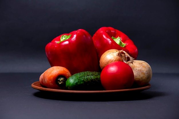 Légumes isolés sur fond noir posés sur une assiette