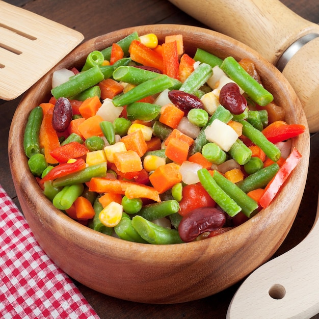 Légumes mélangés dans un bol en bois sur la table de la cuisine