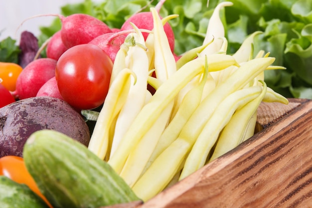 Légumes mûrs frais dans une boîte en bois comme collation saine contenant des vitamines