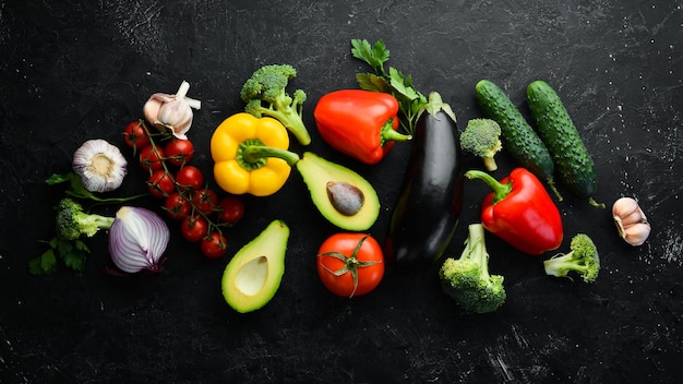 Légumes mûrs Légumes frais sur fond de pierre noire Fruits tropicaux Vue de dessus Espace libre pour votre texte