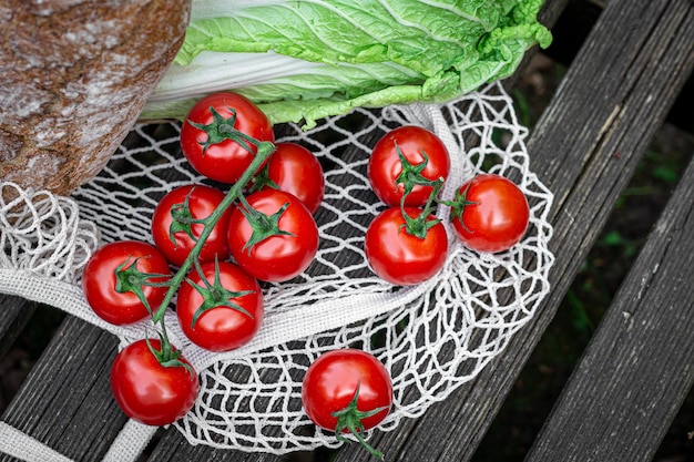 Légumes et pain dans un sac à provisions sur une surface en bois