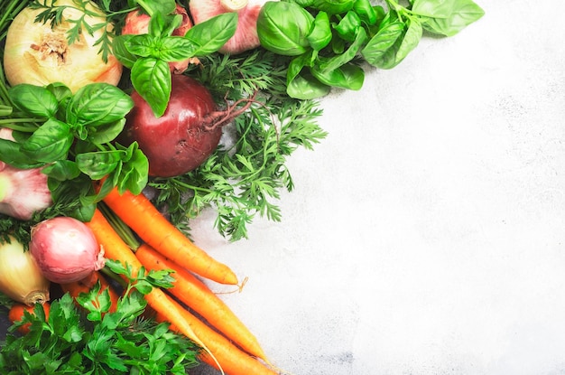 Légumes-racines frais et herbes Aliments sains concept de cuisine d'automne Fond gris avec espace négatif Vue de dessus