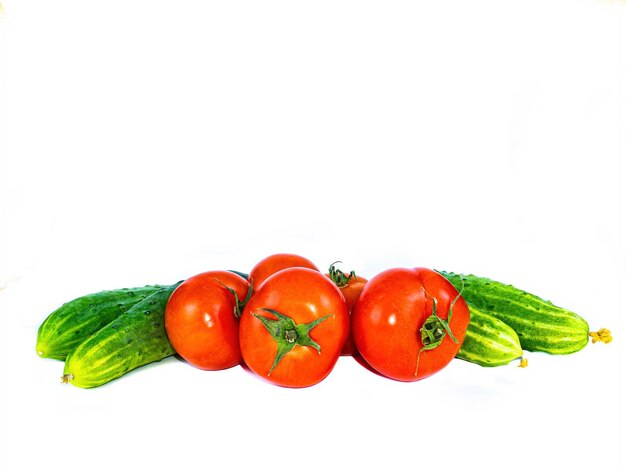 Photo légumes rouges tomates et concombres sur fond blanc