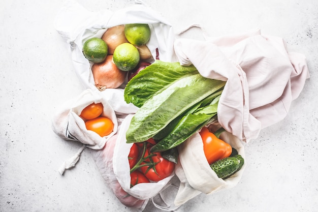 Légumes en sacs de coton écologique, poivron, tomate, laitue, concombre, citron vert, oignon. Zéro gaspillage alimentaire.