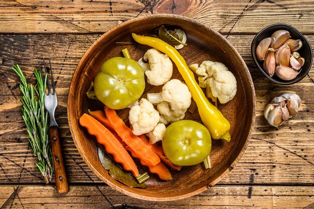 Légumes salés et cornichons conservés dans une assiette en bois