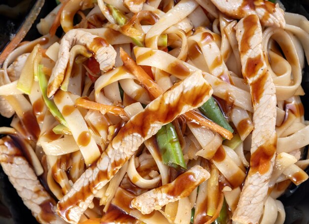 Légumes sautés à l'asiatique dans un wok de poulet Coulé avec de la sauce de gros morceaux de poulet sont visibles