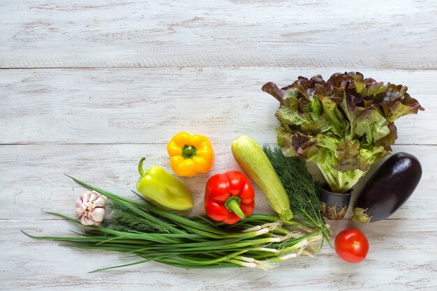 Les légumes sont disposés sur une table en bois blanc. Contexte alimentaire.