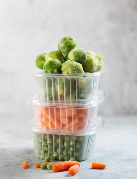 Légumes surgelés tels que pois verts, choux de Bruxelles et carottes miniatures dans les boîtes de rangement