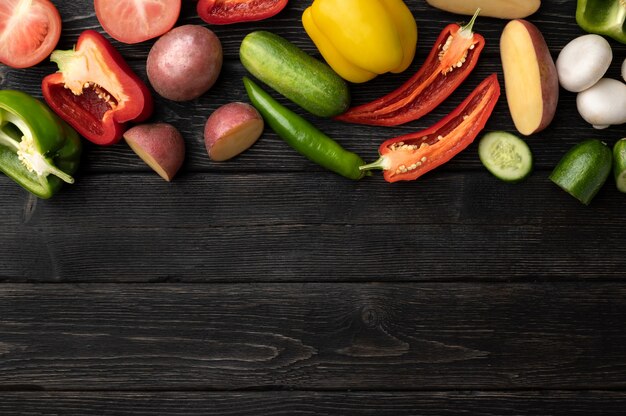 Légumes sur une table en bois noir, vue de dessus et avec copie espace au centre